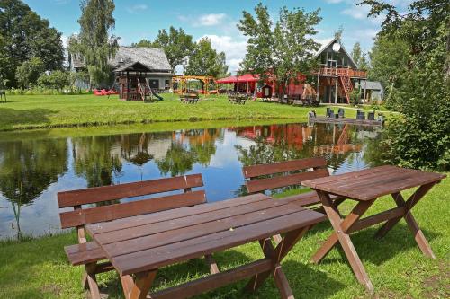 a wooden bench sitting in front of a pond at Kempingas "Obuolių sala" in Molėtai