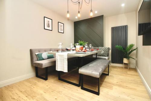 a dining room with a table and a table and chairs at XxHot TubxX 4Bed semi, sleeps 8, 2 bathrooms in Blackpool