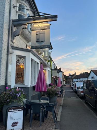 une rue avec des tables et des parasols devant un bâtiment dans l'établissement Castle Hotel, à Eynsford