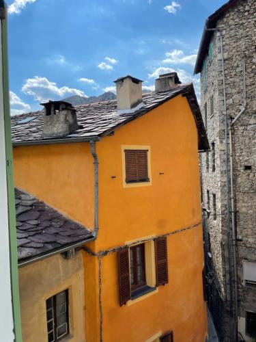 an orange building with windows and a roof at Appartement cocooning in Saorge