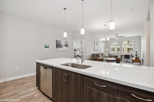 a kitchen with a sink and a living room at LUX 2 BED DESERT RIDGE 2 HEATED POOLS GYM in Phoenix