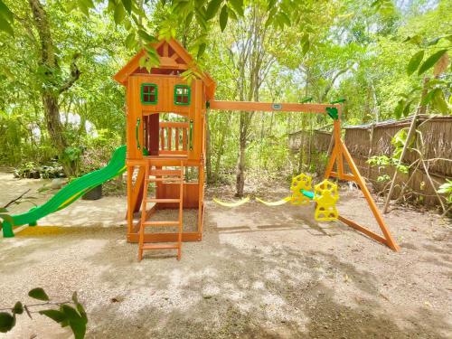 a playground with a swing and a play structure at Ku kuk Glamping in Chemuyil