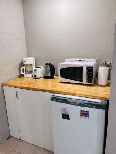 a counter with a microwave on top of a refrigerator at BOG Angostura Apartments in Villa La Angostura