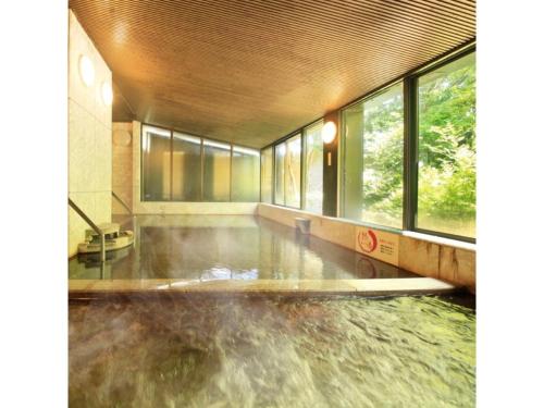 a pool of water in a room with windows at Kasuga no mori - Vacation STAY 80247v in Saku
