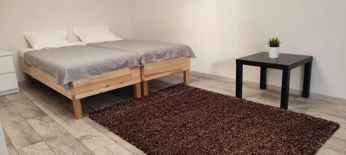 a bedroom with a bed and a side table at Apartamenty Wilga spokojne miejsce z całorocznym jacuzzi i letnim basenem in Wilga