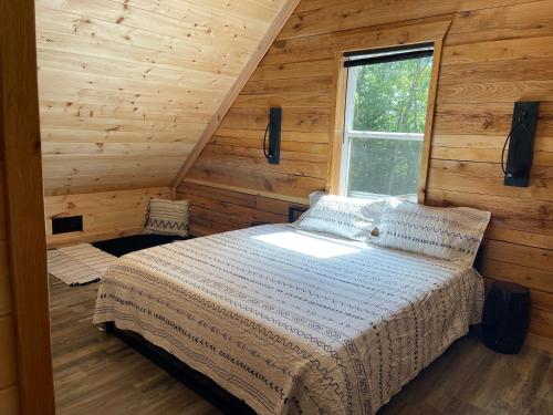 a bedroom with a bed in a room with wooden walls at windrock ridge - Ethan in Oak Ridge