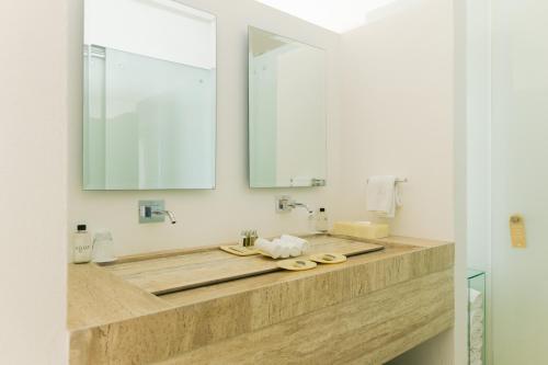 a bathroom with a sink with a large mirror at Encanto Acapulco in Acapulco
