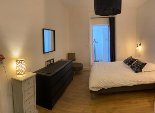 a bedroom with a bed and a dresser and a window at LA VILLE A LA MER N°1 in Concarneau