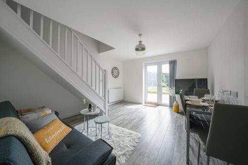 a living room with a blue couch and a staircase at Stylish 2-bed home - For Company contractor and Leisure stays - NEC, Airport, HS2, Contractors, Resort World in Birmingham