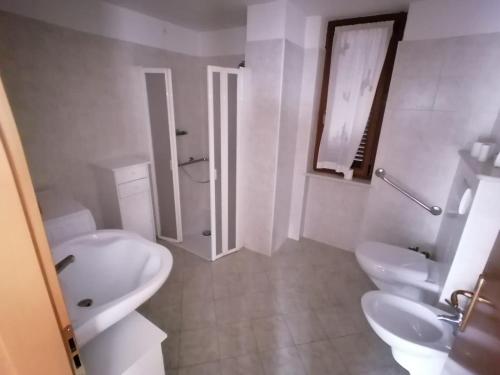 a white bathroom with two sinks and a shower at Apt. BELLA VISTA nel Cuore della Valle di Cembra. in Segonzano