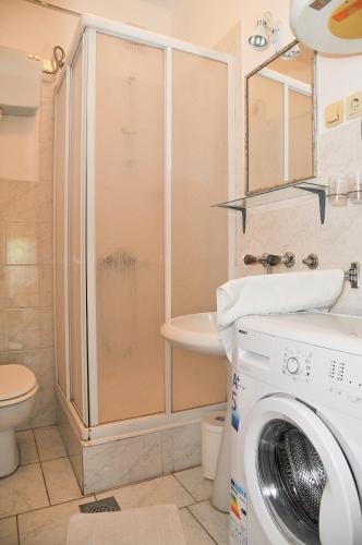 a bathroom with a shower and a washing machine at Guesthouse Lanca in Tivat