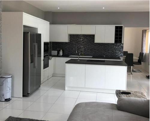 a kitchen with white cabinets and a black counter top at Belle Luxury Apartments in Gros Islet