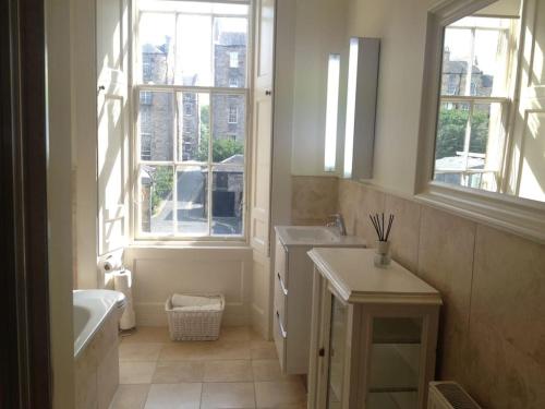 a bathroom with a tub sink and a window at Beautiful Georgian New Town Flat in Edinburgh