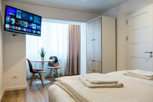 a hotel room with a bed with a tv on the wall at Straja Apart in Lupeni