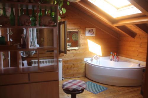 a bathroom with a tub in a wooden house at Bed and Breakfast La Casa del Sole in Momperone
