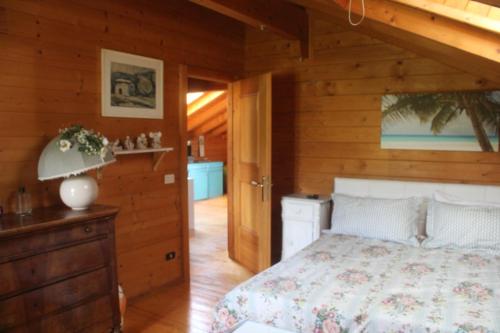 ein Schlafzimmer mit einem Bett und einer Holzwand in der Unterkunft Bed and Breakfast La Casa del Sole in Momperone