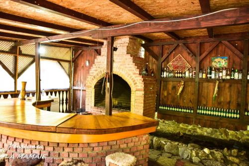 a bar in a building with a brick fireplace at Pensiunea La Mamaie in Cheia