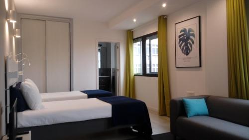 Habitación de hotel con 2 camas y sofá en Beach Studios, en Las Palmas de Gran Canaria