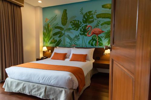 a bedroom with a large bed with a painting on the wall at Giraffe Boutique Hotel in Baguio