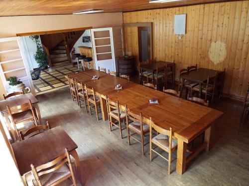 Habitación con una gran mesa de madera y sillas. en Au coeur du Volcantal, en Laveissière