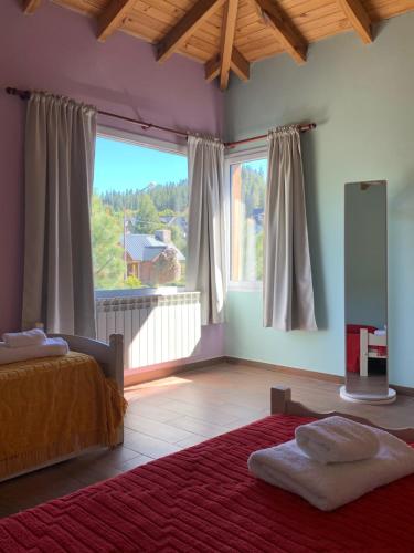 ein Schlafzimmer mit einem Bett und einem großen Fenster in der Unterkunft Lo de Gustavo in Esquel