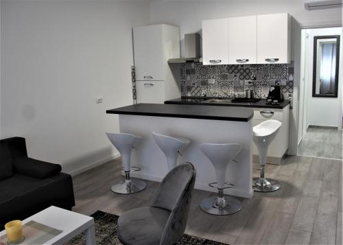 een keuken met een aanrecht en stoelen in de woonkamer bij Tiziano T1 in Zagreb