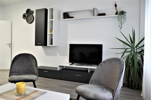 een woonkamer met twee stoelen en een televisie bij Tiziano T1 in Zagreb