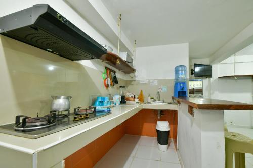 a small kitchen with a stove and a sink at Posada Amaripucci in San Andrés