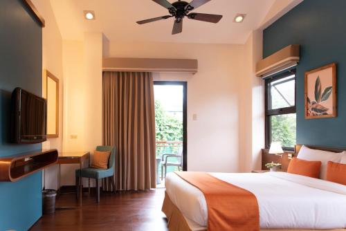 a hotel room with a bed and a desk and a window at Giraffe Boutique Hotel in Baguio