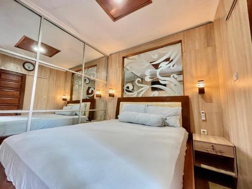 - une chambre avec un lit et un miroir dans l'établissement ElBanna FAmily Home syariah 5BR, à Malang