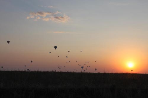 a group of kites flying in the sky at sunset at Soleado Cappadocia Hotel in Uchisar