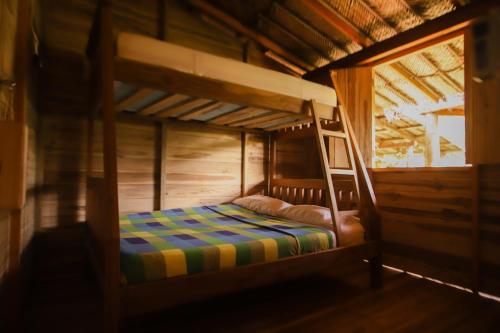 a wooden bunk bed in a wooden cabin at Puerto Manglar Hostel in Guachaca