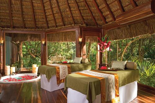 a room with a table, chairs, and a canopy at Dreams Tulum Resort & Spa in Tulum