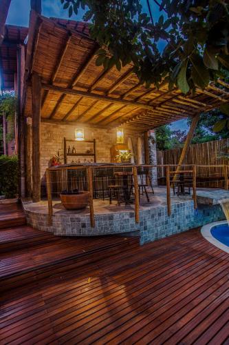 a patio with a wooden deck with a table and chairs at Pousada Alecrim do Campo in Sao Jorge