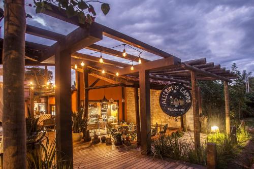 a restaurant with a wooden deck at night at Pousada Alecrim do Campo in Sao Jorge