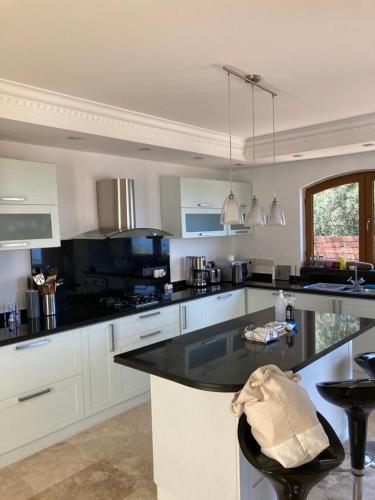 a kitchen with white cabinets and a black counter top at Spectacular views from this villa in Lapta in Kérynia