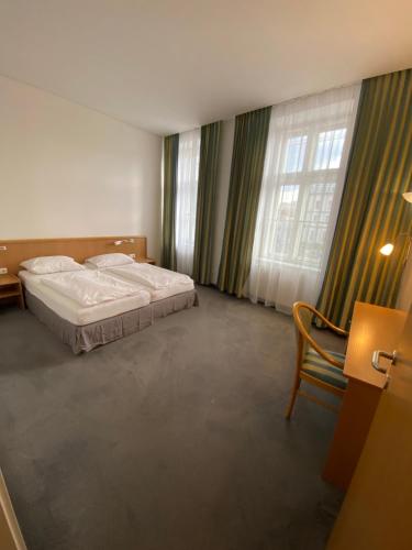 1 dormitorio con 2 camas, silla y ventana en Kolbeck Rooms en Viena
