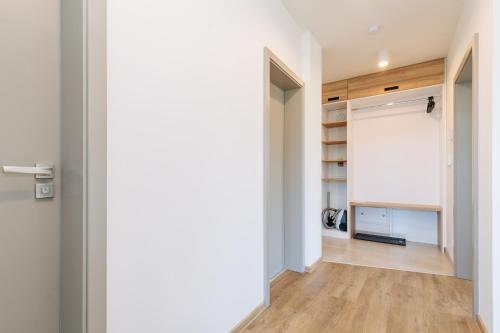 a hallway with a door leading into a room with wood floors at Enzian by Mountain ways in Loučná pod Klínovcem