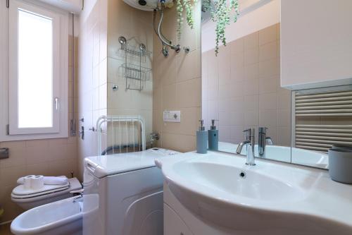 Baño blanco con lavabo y aseo en PrimoPiano - Biancospini, en Milán