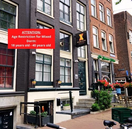 un edificio con una señal que lee la retención de la edad de atención para cableado hacia abajo en Xplore Hostel Amsterdam, en Ámsterdam