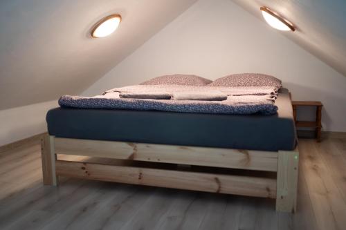 a bed on a wooden platform in a attic at Przytulny Domek z Banią in Brzozowa