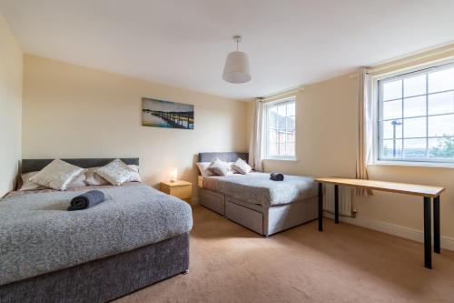 sypialnia z 2 łóżkami, stołem i oknem w obiekcie NEWCASTLE CITY CENTRE TOWN HOUSE free parking and wifi w mieście Newcastle upon Tyne