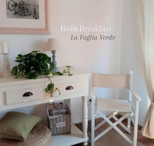 a white desk with a chair and a plant on it at B&B La Foglia Verde in Massa