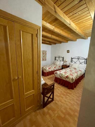 a room with two beds in a room at La Serrota Casa Rural in Navacepedilla de Corneja