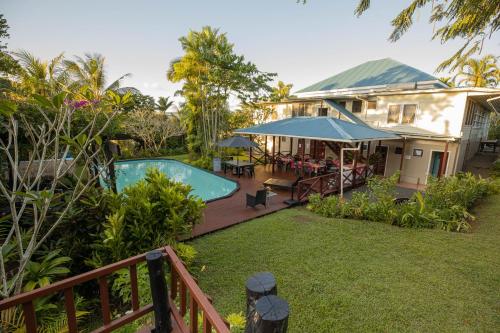 a house with a swimming pool in the yard at The Samoan Outrigger Hotel in Apia