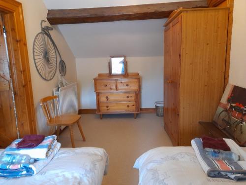Zimmer mit einem Schlafzimmer mit einer Kommode und einem Bett in der Unterkunft Berwick Hall Cottage in Moira