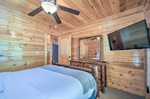a bedroom with a bed and a flat screen tv at Hiwassee Hideaway Cabin with Mountain Views! in Turtletown