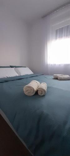 two towels are laying on a bed in a room at Apartmani Sunlight in Vrnjačka Banja