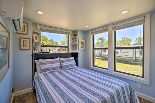 Un dormitorio con una cama y dos ventanas. en Upscale Tiny Home - Boho-Chic Austin Getaway!, en Austin