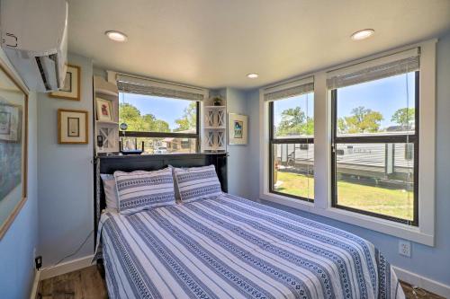 1 dormitorio con 1 cama y 2 ventanas en Upscale Tiny Home - Boho-Chic Austin Getaway! en Austin
